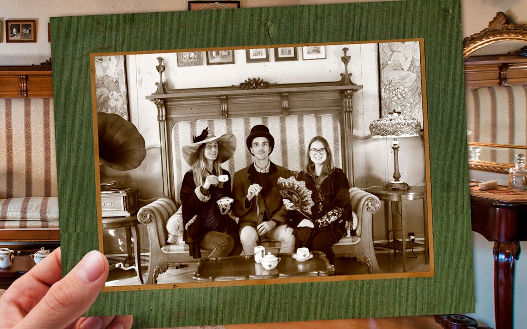 Visitors in vintage attire enjoying tea at Casa Batlló, Barcelona, with period decor.