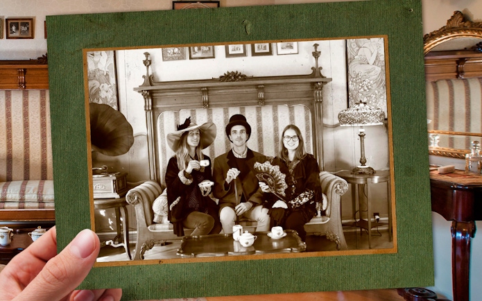 Visitors in vintage attire enjoying tea at Casa Batlló, Barcelona, with period decor.