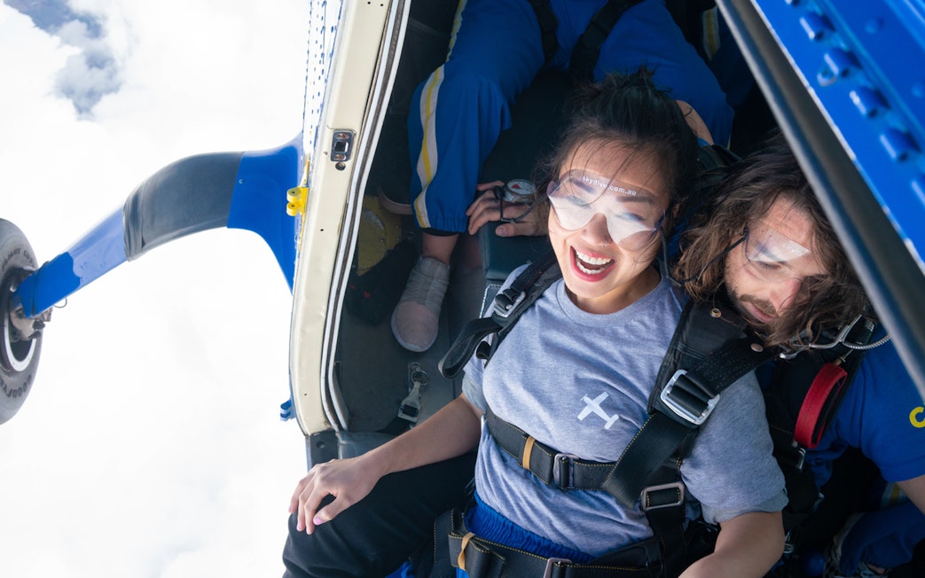Tandem skydivers preparing to jump from a plane over Great Ocean Road.
