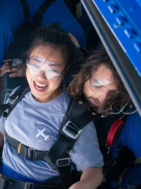 Tandem skydivers preparing to jump from a plane over Great Ocean Road.
