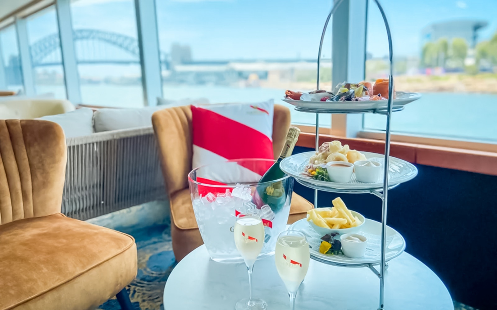 Afternoon tea setup with champagne on Captain Cook Harbour Bar Cruise, Sydney Harbour Bridge in view.