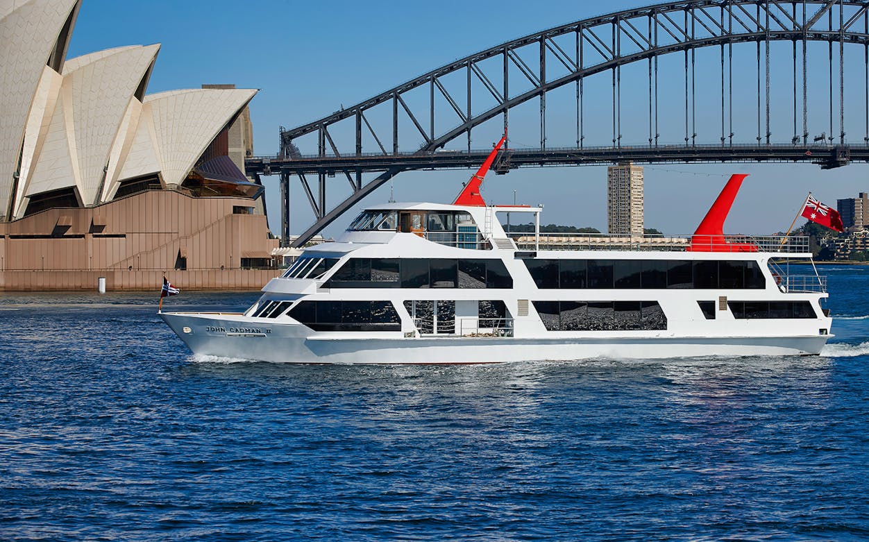 Cruise ship sailing near Sydney Opera House and Harbour Bridge.