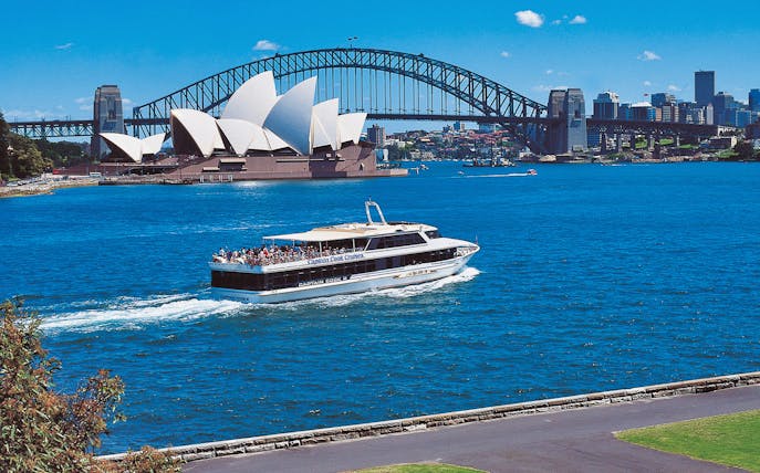 Cruise boat on Sydney Harbour with Opera House and Harbour Bridge in view.