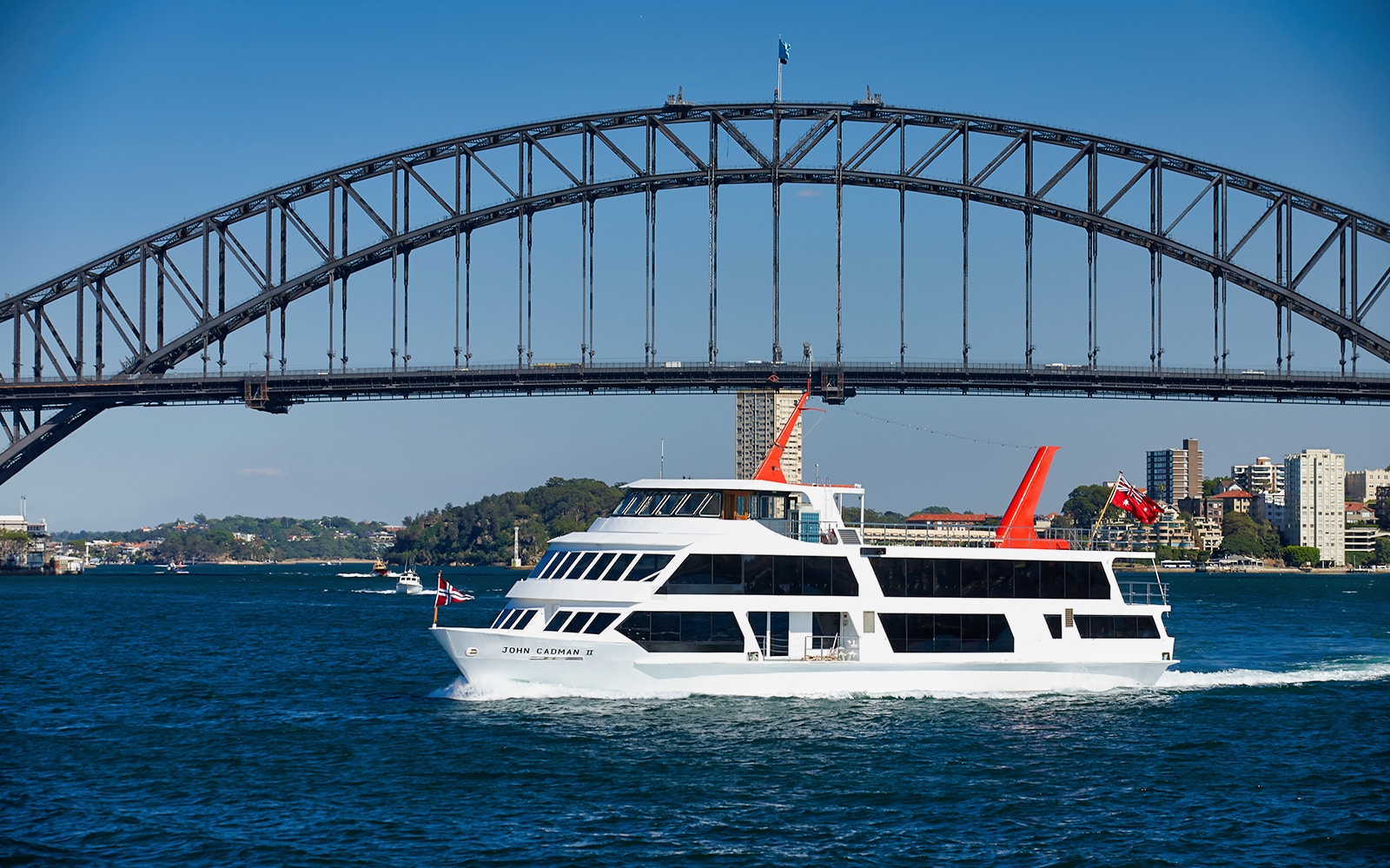 Sydney Harbour cruise ship with dining setup on top deck, showcasing views of the iconic Sydney Opera House.