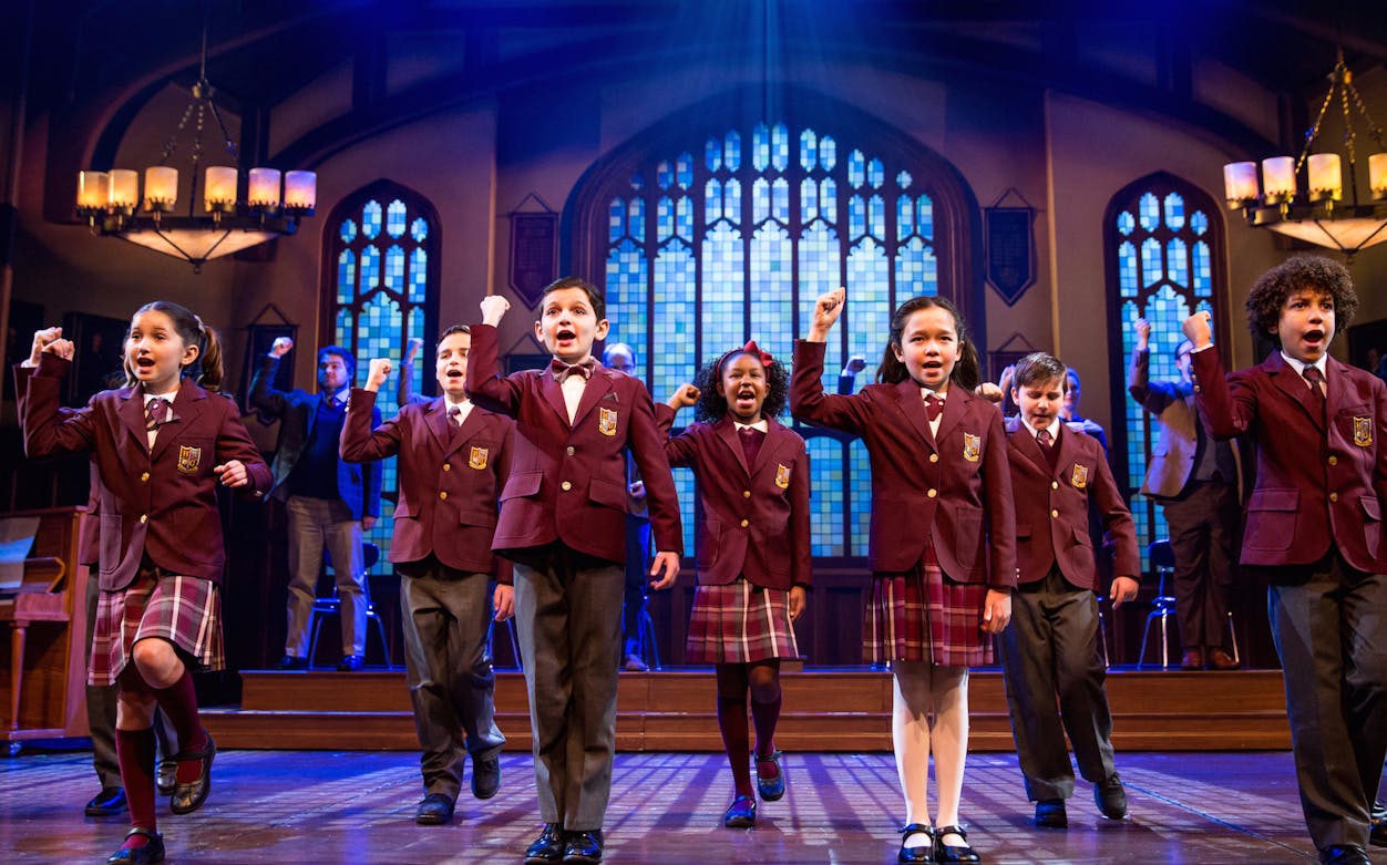 Children performing on stage in school uniforms at School of Rock, Covent Garden.