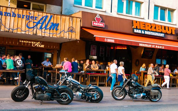 Hamburg St Pauli street scene with motorcycles and people outside bars.