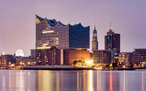 Elbphilharmonie concert hall illuminated at dusk in Hamburg's HafenCity.