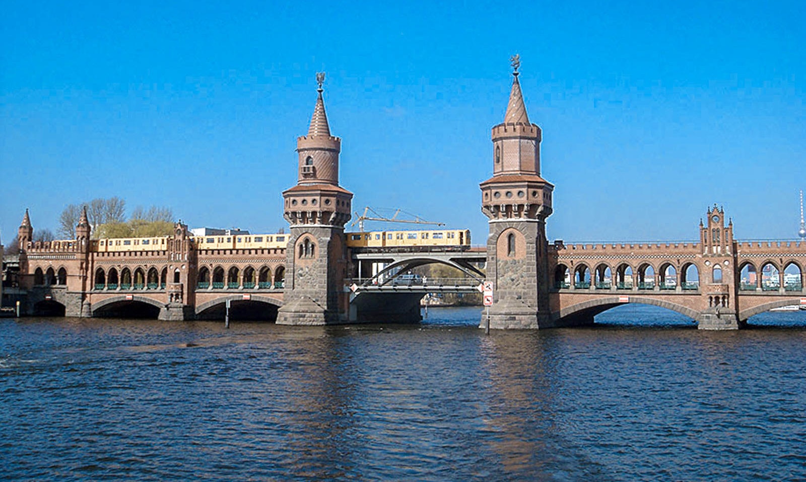 Woman enjoying a scenic Berlin river cruise with city landmarks in the background.