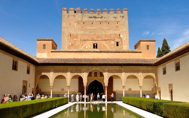 Alhambra's courtyard with reflecting pool and intricate arches, Granada, Spain.