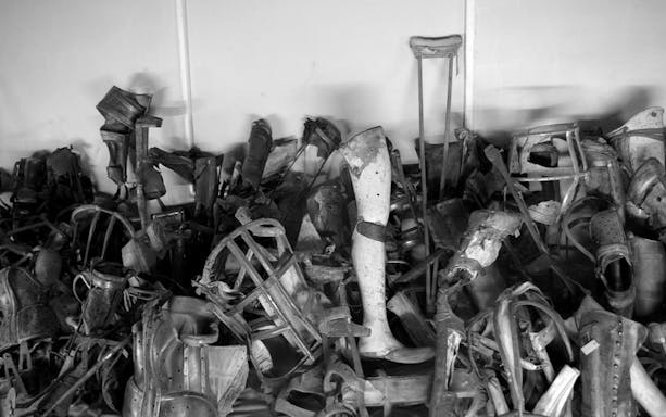 Prosthetic limbs and crutches displayed at Auschwitz Birkenau Museum, Krakow tour.