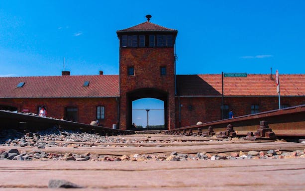 Auschwitz Birkenau entrance gate with railway tracks, part of museum tour from Krakow.