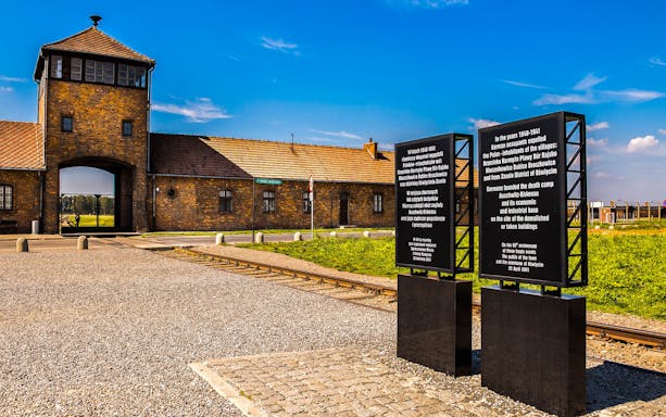 Auschwitz Birkenau entrance with historical sign, part of museum tour from Krakow.