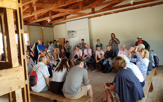 Visitors listening to a guide at Dachau Concentration Camp Memorial Site.