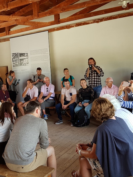 Visitors listening to a guide at Dachau Concentration Camp Memorial Site.