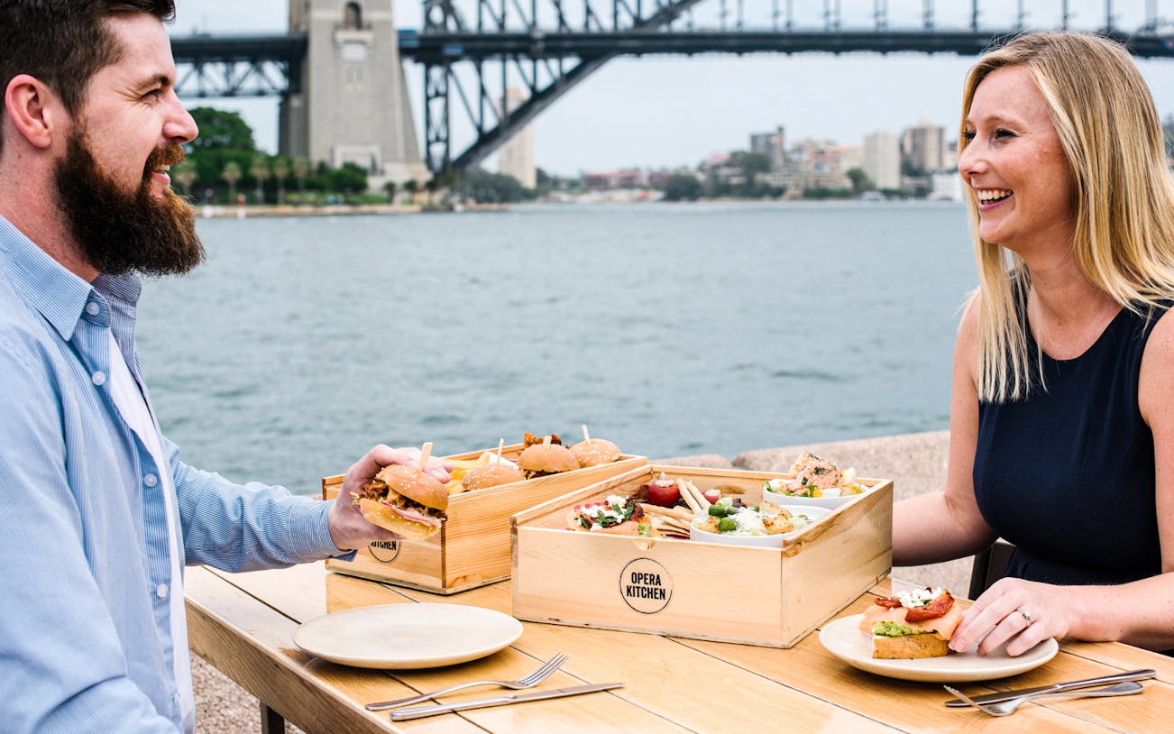 Couple enjoying tasting plates at Opera Kitchen with Sydney Harbour Bridge view.