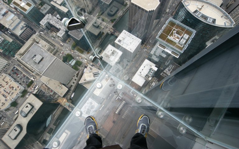 View from Sky Deck Chicago glass ledge overlooking city buildings.