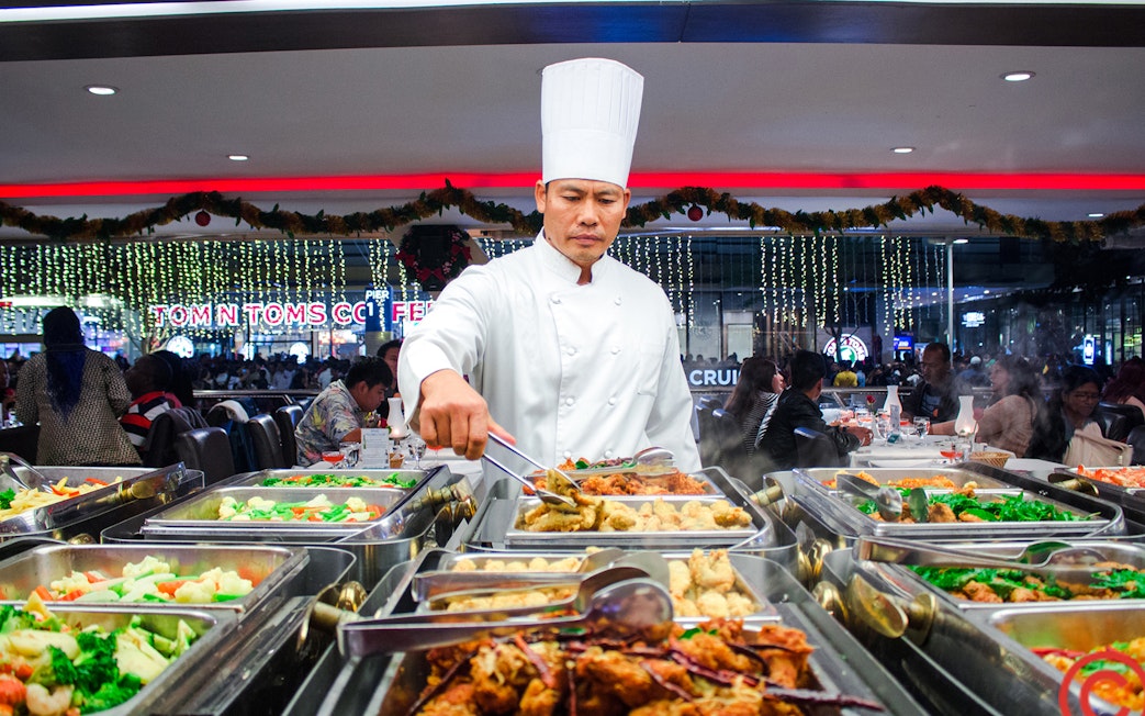 Chef serving buffet on Chao Phraya dinner cruise in Bangkok.
