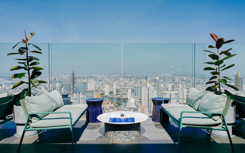 Rooftop view from Mahanakhon SkyWalk overlooking Bangkok skyline and Chao Phraya River.