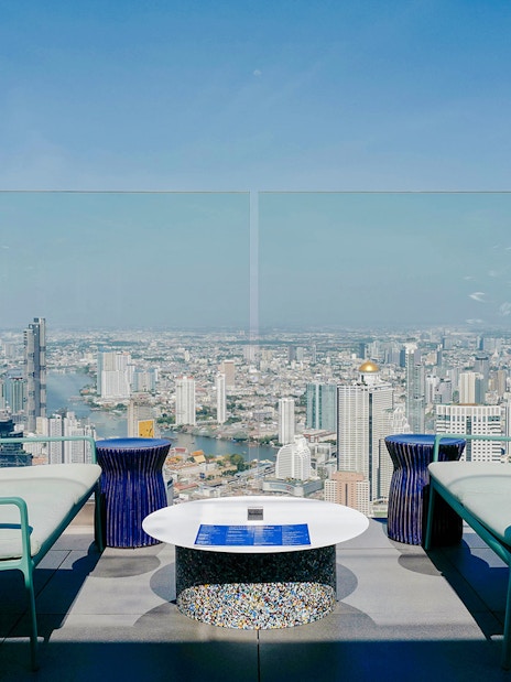 Rooftop view from Mahanakhon SkyWalk overlooking Bangkok skyline and Chao Phraya River.
