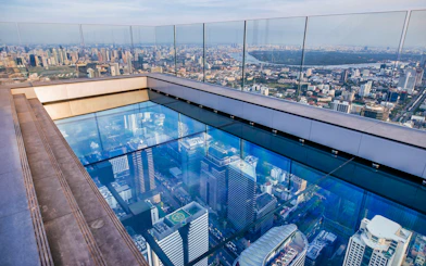 Mahanakhon SkyWalk glass floor with Bangkok city view.