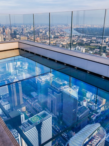 Mahanakhon SkyWalk glass floor with Bangkok city view.
