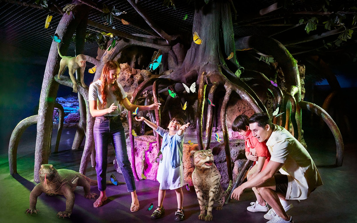 Family exploring interactive exhibit with butterflies and animals at Sealife Bangkok.