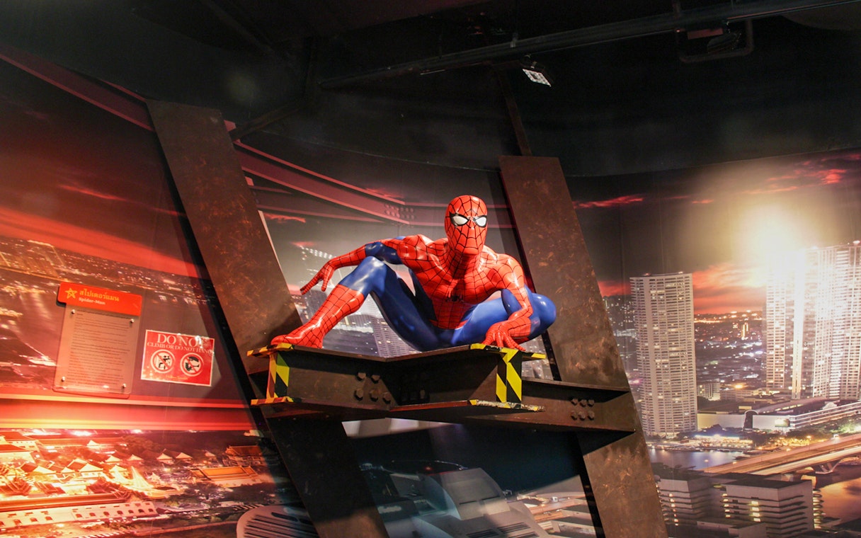 Spider-Man figure at Madame Tussauds Bangkok with cityscape backdrop.