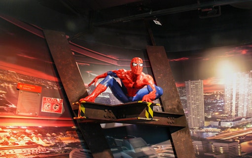 Spider-Man figure at Madame Tussauds Bangkok with cityscape backdrop.