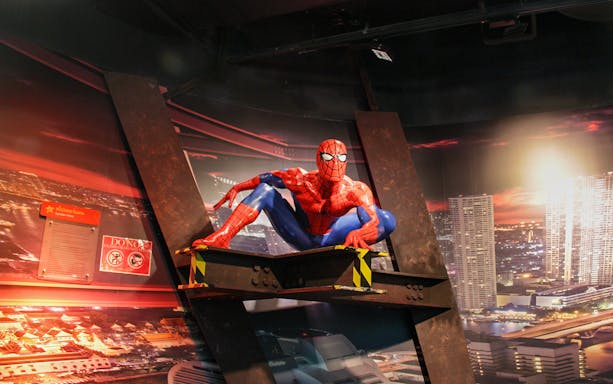 Spider-Man figure at Madame Tussauds Bangkok with cityscape backdrop.