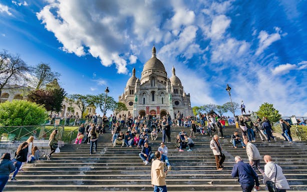 Visitors on steps of Sacré-Cœur Basilica, Montmartre, Paris, during Headout Exclusive walking tour.