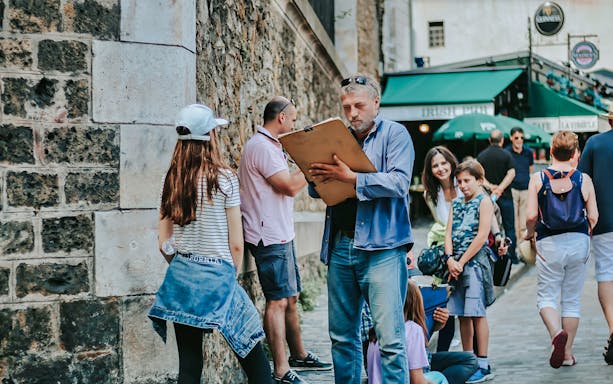 Artist sketching a girl on a Montmartre walking tour, Paris street scene.
