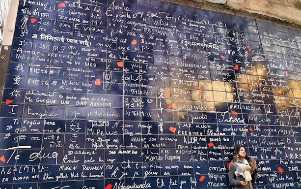 Wall of Love in Montmartre with multilingual "I love you" phrases, Paris walking tour.