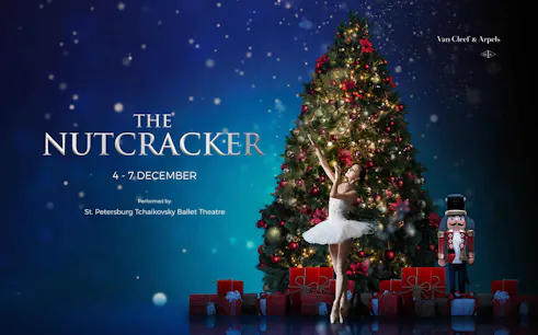 Ballerina performing in front of a Christmas tree for The Nutcracker ballet.