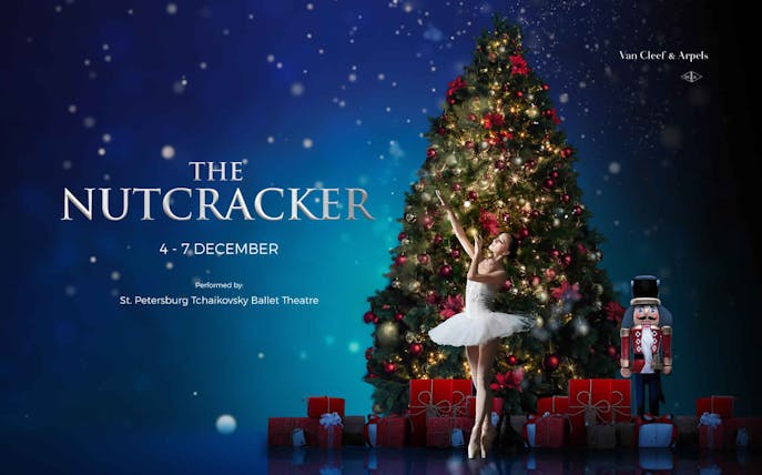 Ballerina performing in front of a Christmas tree for The Nutcracker ballet.
