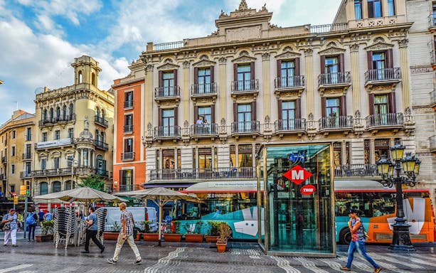 Barcelona Gothic Quarter street scene with historic buildings and metro entrance.