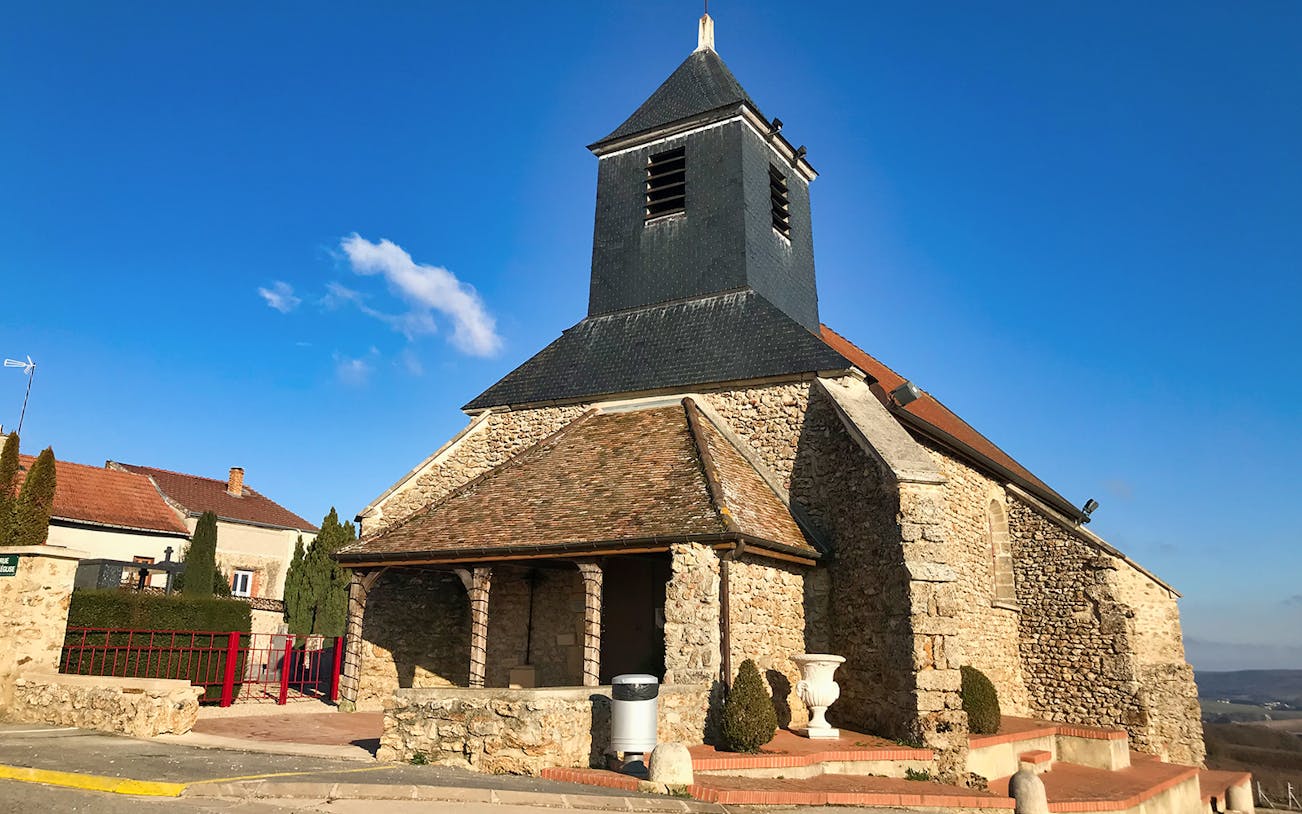 Stone church in Reims, France, with blue sky backdrop on Champagne tour from Paris.
