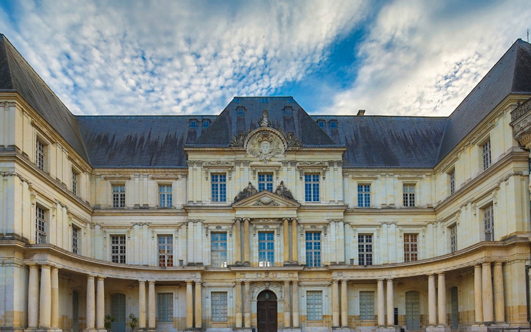 Facade of Château de Blois with ornate architecture under a cloudy sky, Chaumont sur Loire.