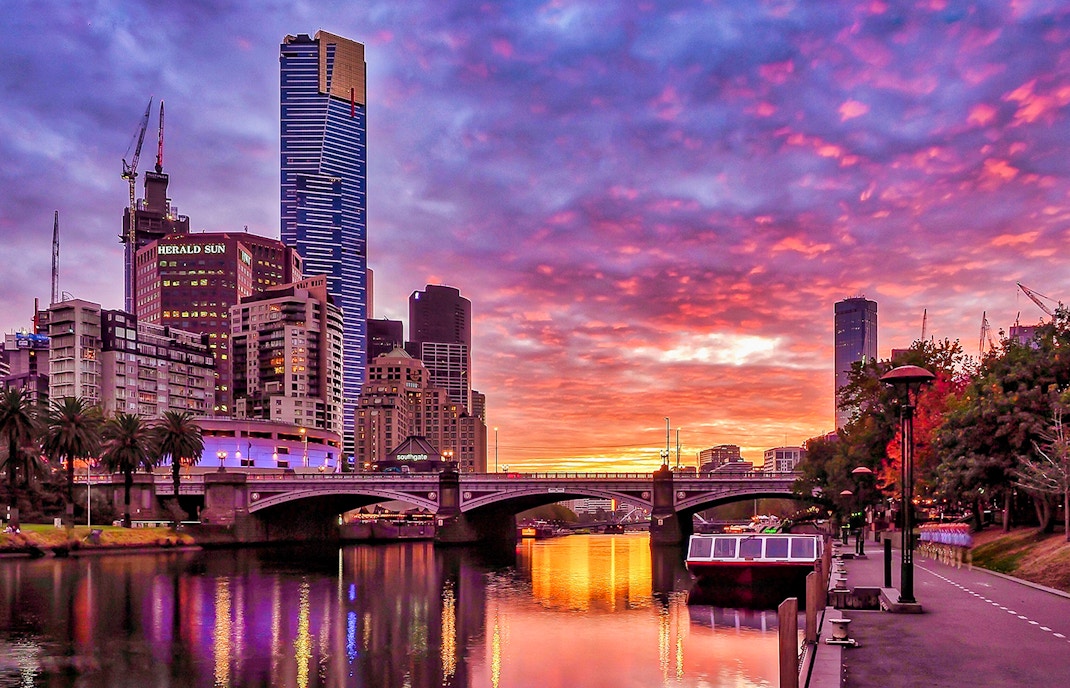 Melbourne skyline at sunset with Eureka Tower and Yarra River.