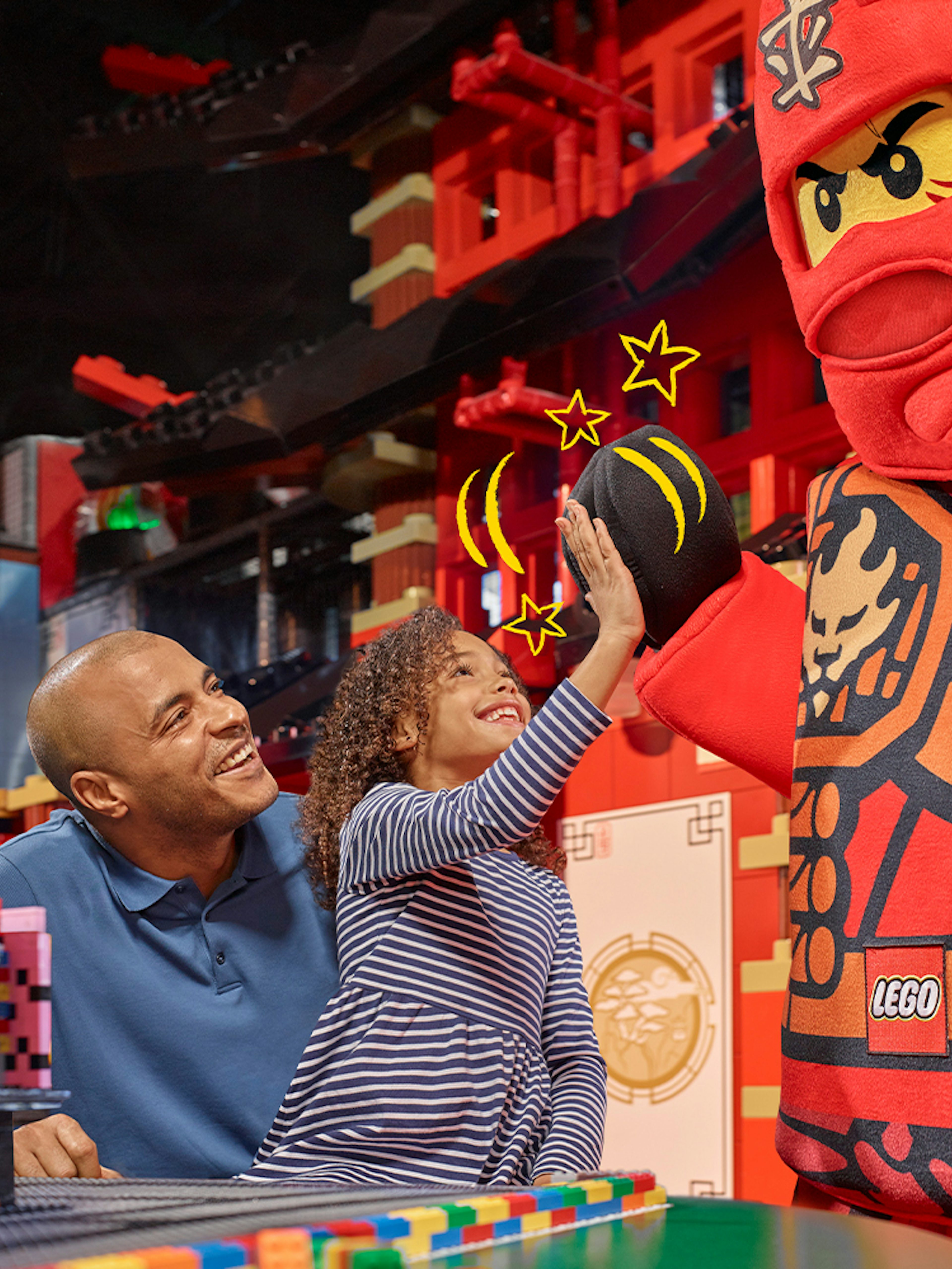 Child high-fiving LEGO character at LEGOLAND Discovery Centre Berlin entrance.