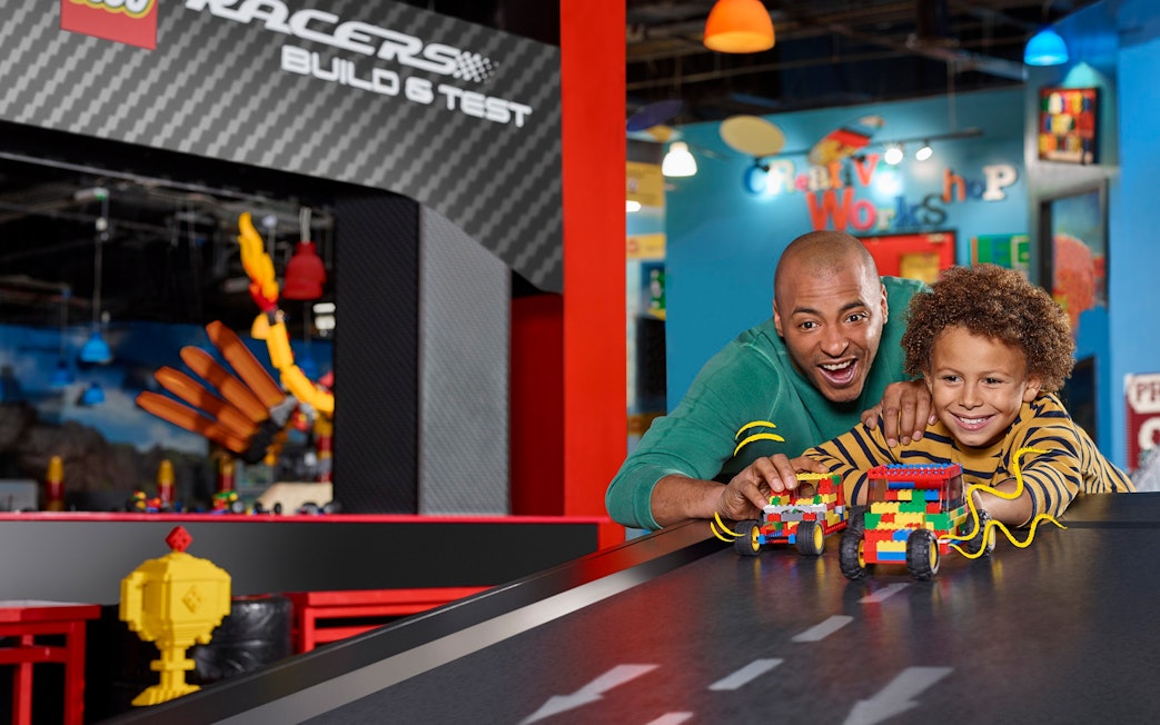 Families enjoying interactive Lego car racing at LEGOLAND Discovery Centre Berlin.