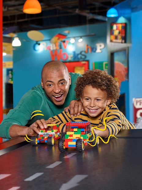 Families enjoying interactive Lego car racing at LEGOLAND Discovery Centre Berlin.