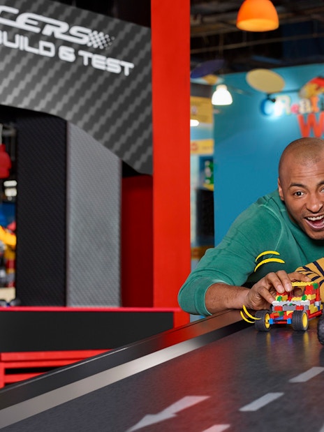 Families enjoying interactive Lego car racing at LEGOLAND Discovery Centre Berlin.