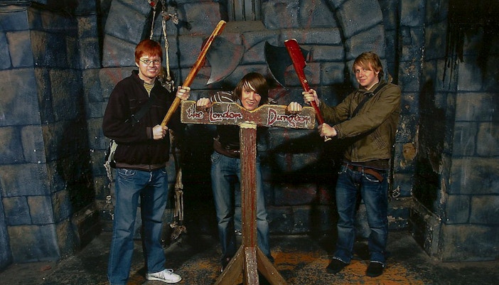 Visitors posing with props at the London Dungeon attraction.