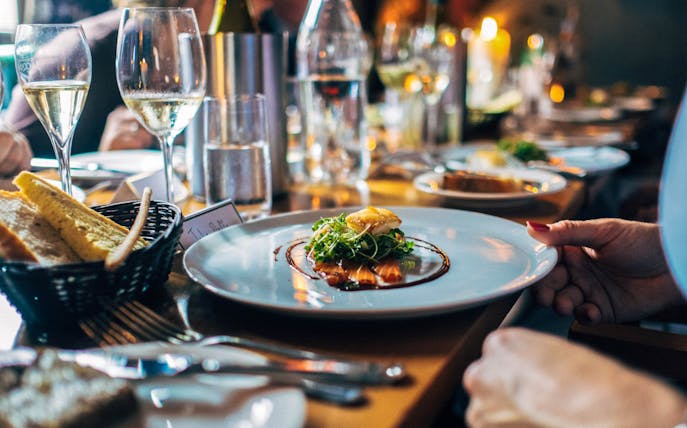 Lunch setting at Berlin TV Tower with gourmet dish and wine glasses.