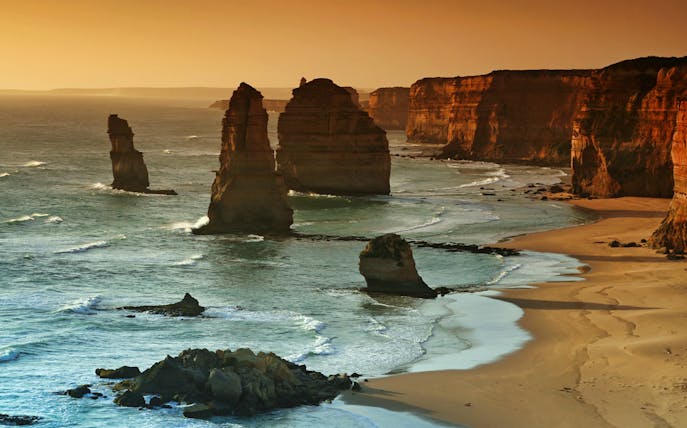 Twelve Apostles rock formations along Great Ocean Road at sunset.