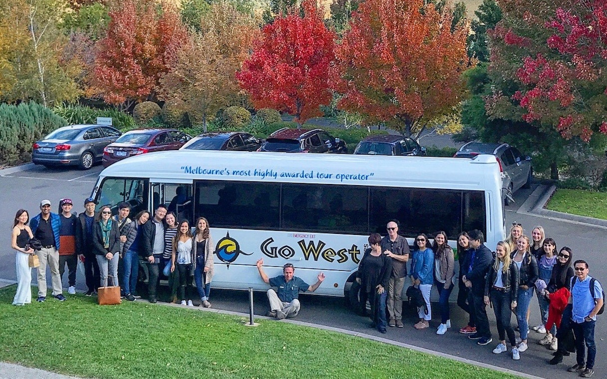 Group of tourists beside a tour bus in Yarra Valley during a guided gourmet tour.