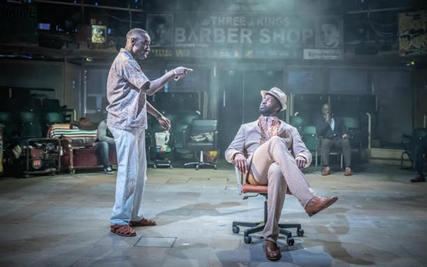 Barber Shop Chronicles stage scene with two actors in conversation.