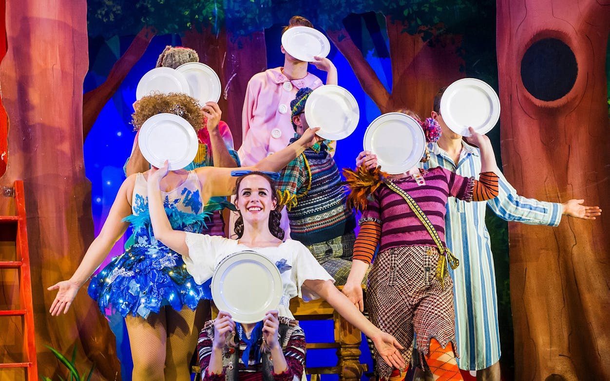 Performers on stage holding plates in a scene from "Peter Pan Goes Wrong.