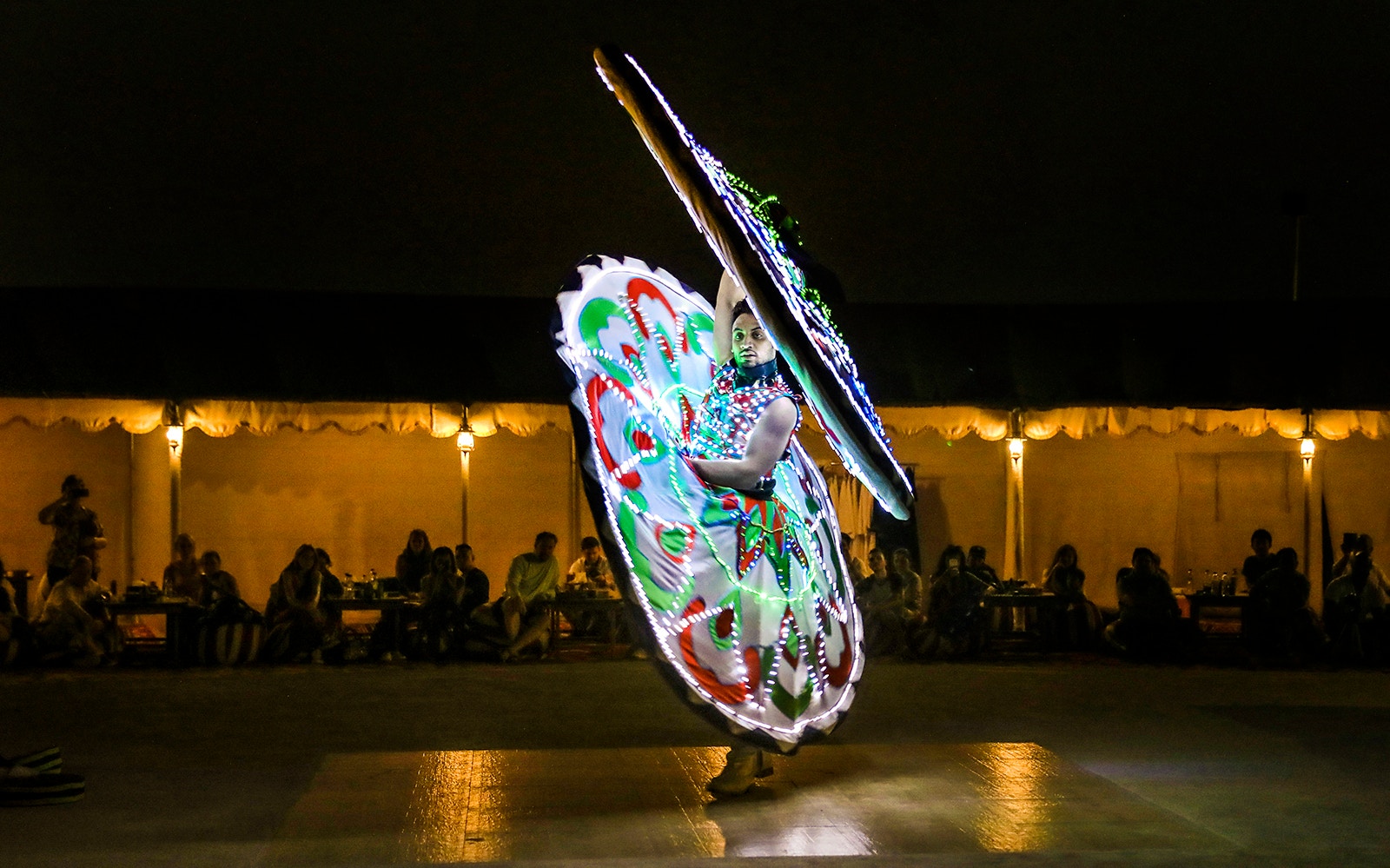 Tanoura dancer performing in Dubai with colorful illuminated skirt.