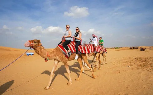 Camel ride in desert during 45 mins red dune bashing tour with sandboarding and BBQ.